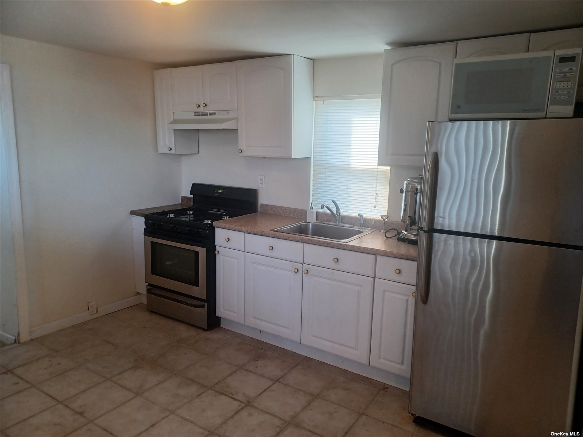 a kitchen with cabinets and refrigerator