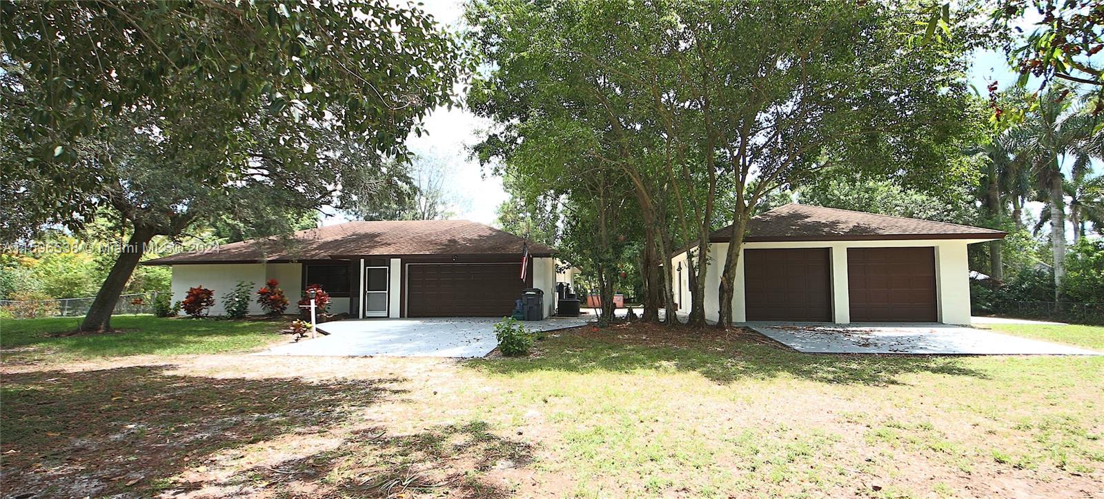 a front view of house with yard and trees around