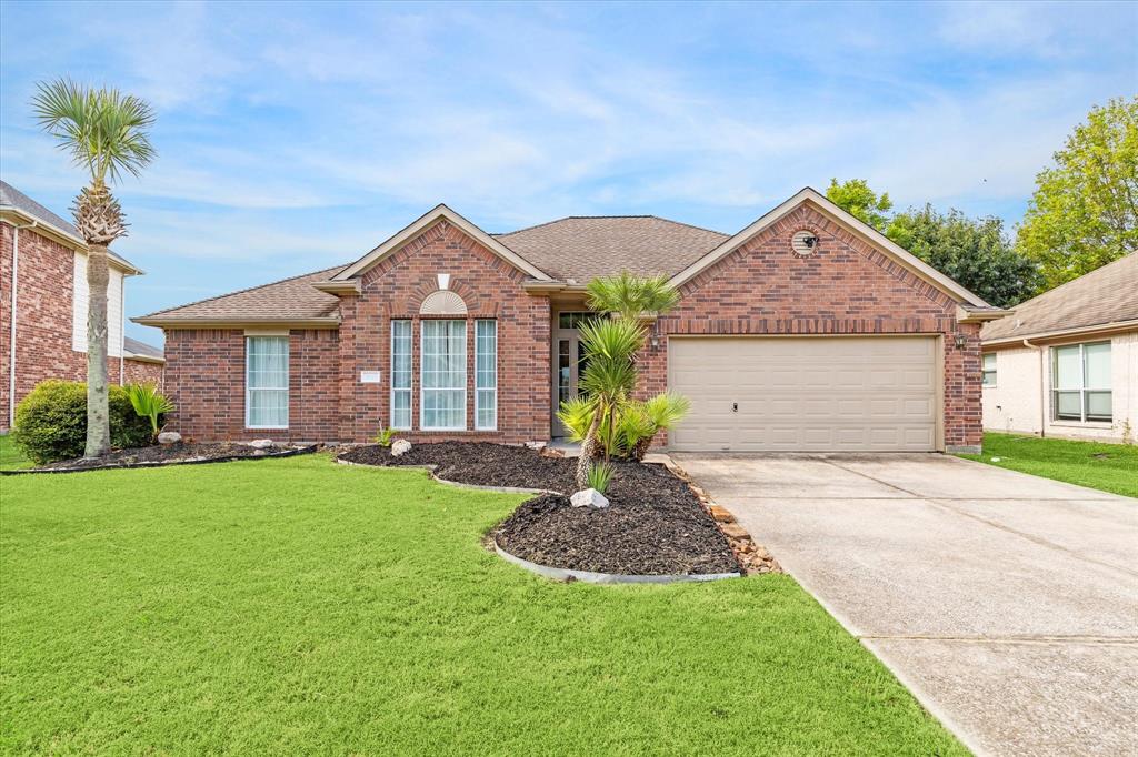 a front view of a house with a garden and yard