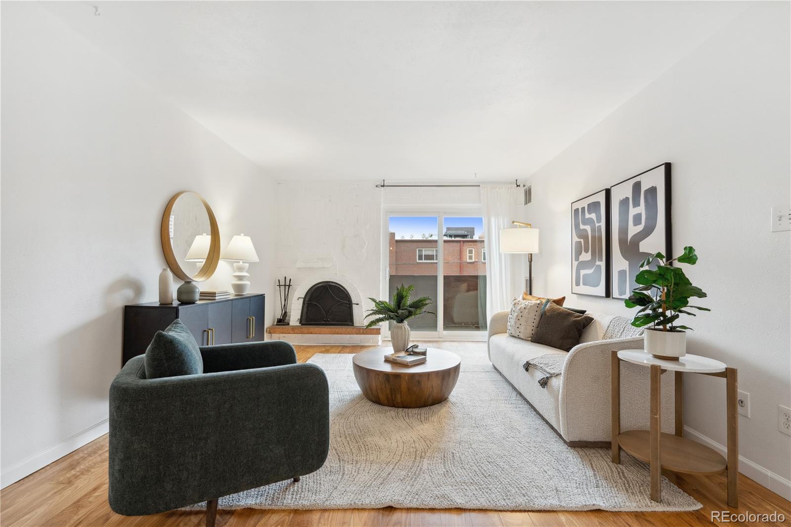 a living room with furniture potted plant and a large window