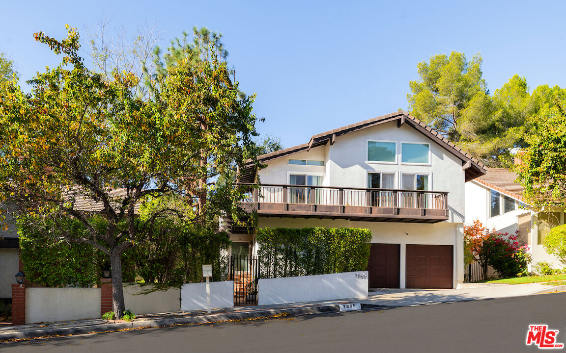 a view of a house with a tree and plants