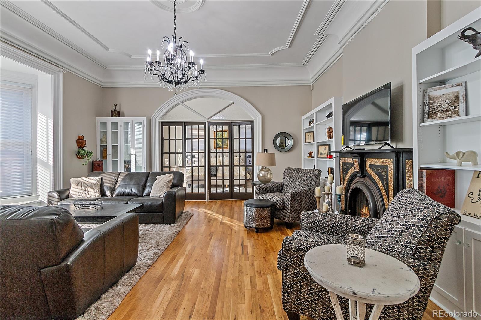 a living room with furniture a chandelier and a fireplace