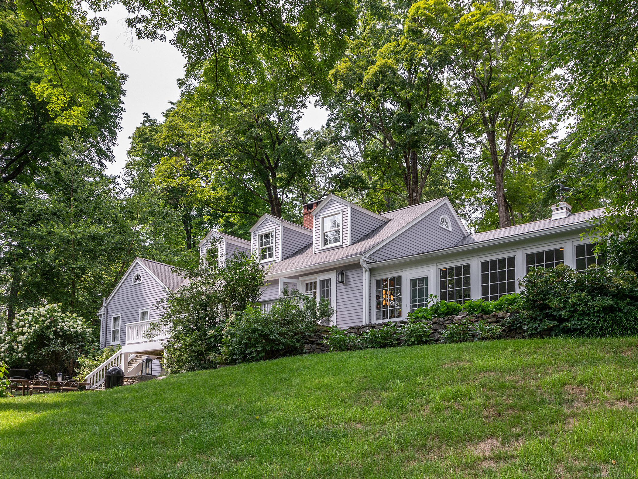 a front view of a house with a yard and trees