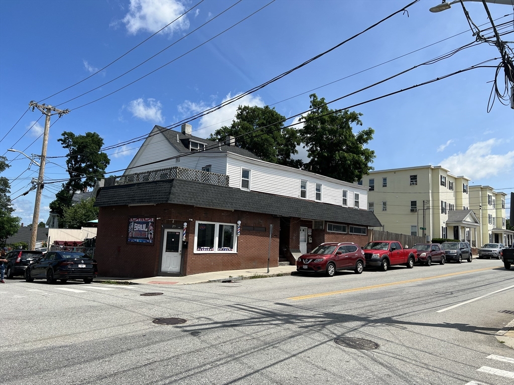 a view of a building with car parked on the road