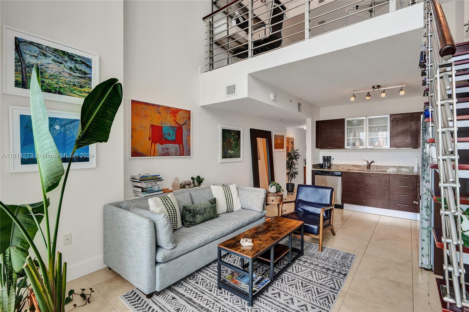 a living room with furniture a wooden floor and a kitchen view