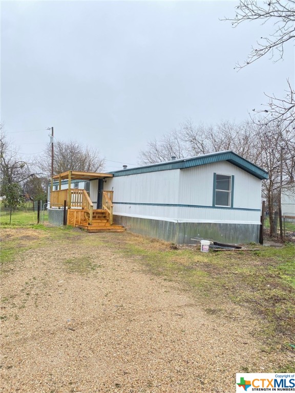 a view of a house with backyard and trees in the background