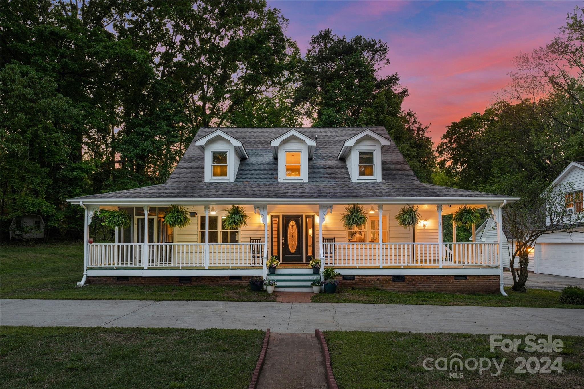 a front view of a house with a garden and yard