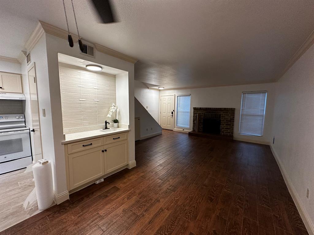 a large kitchen with a wooden floor and a window