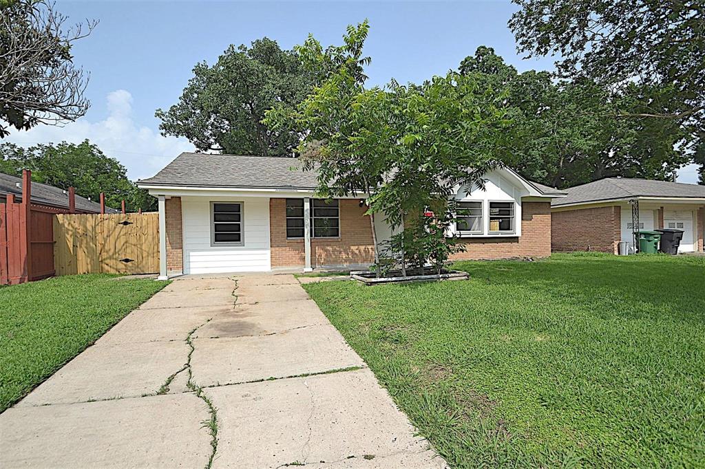 a front view of a house with a garden and trees