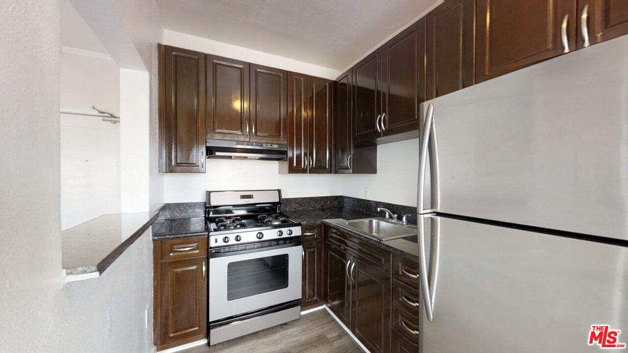 a kitchen with granite countertop a stove and a refrigerator