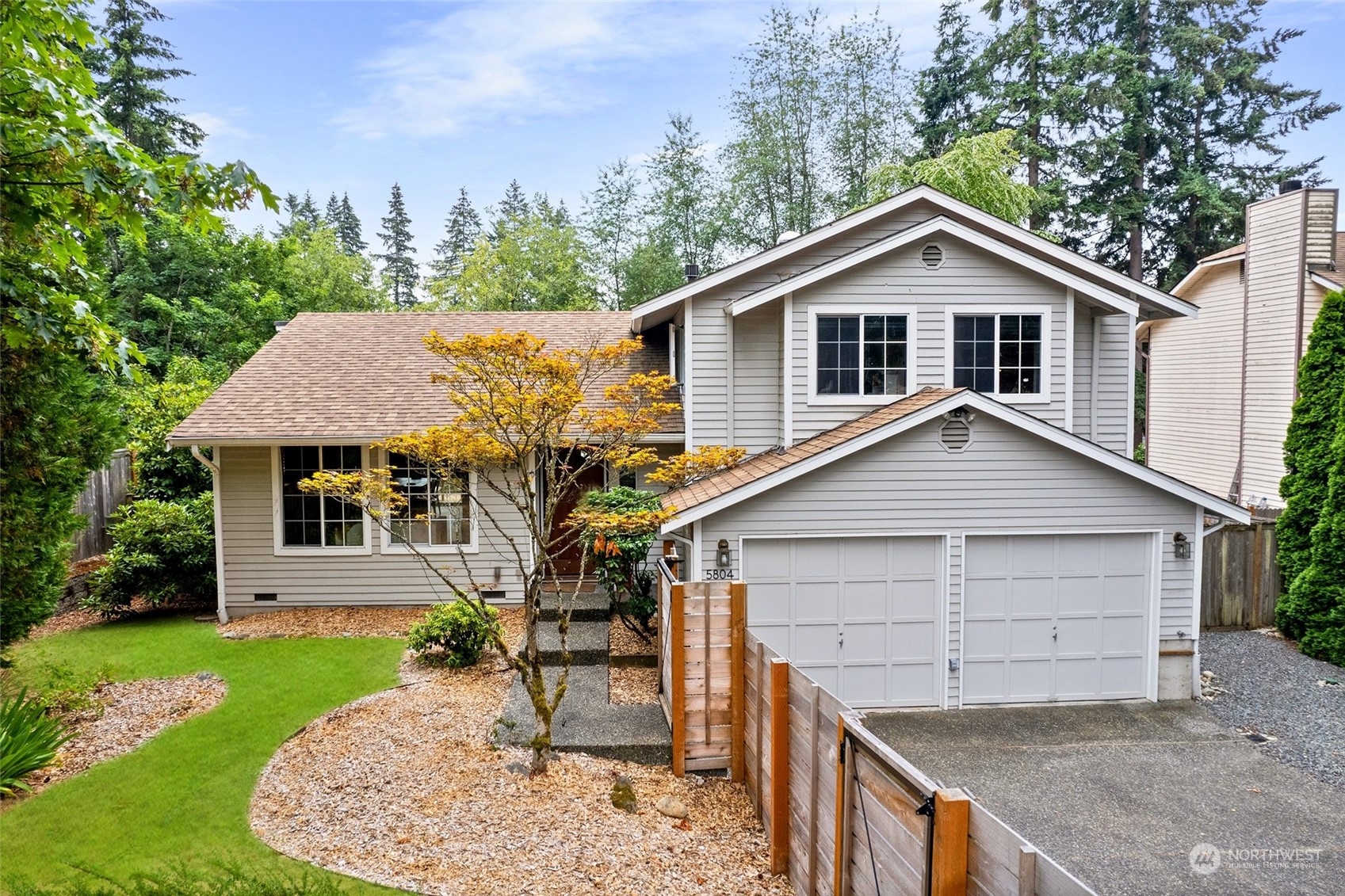 a view of house with a yard and potted plants