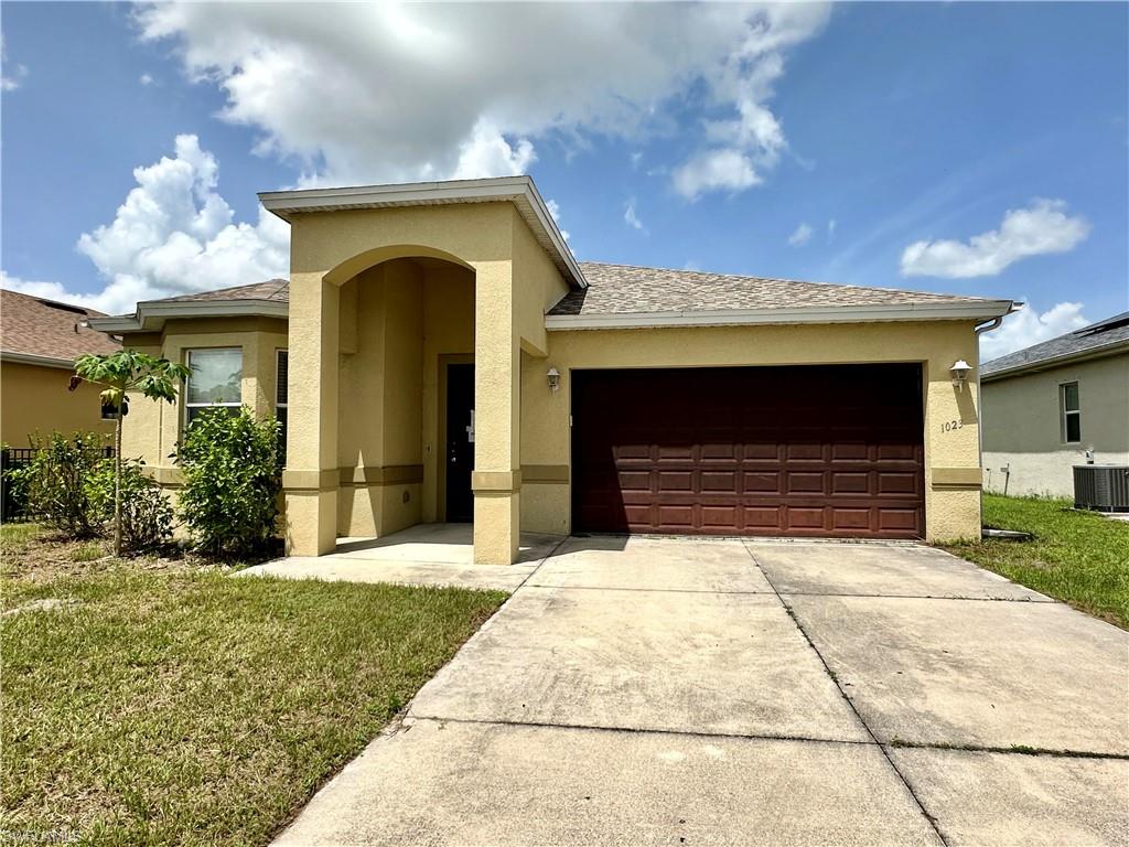 a front view of a house with a yard and garage