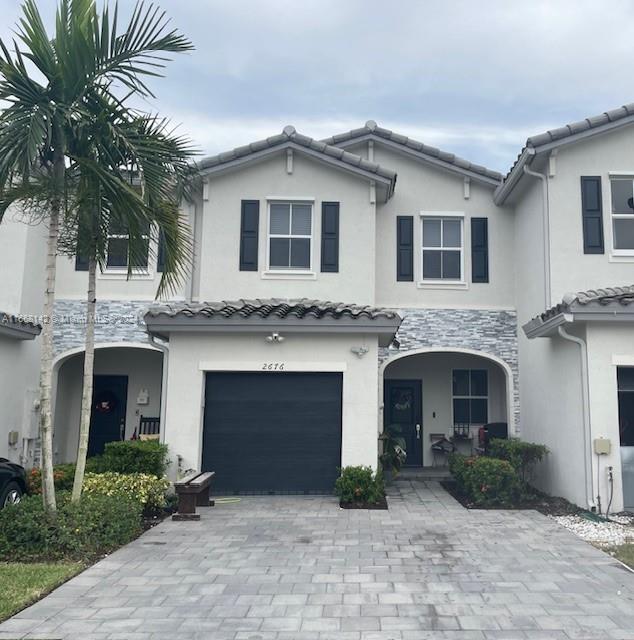 a front view of a house with yard and parking