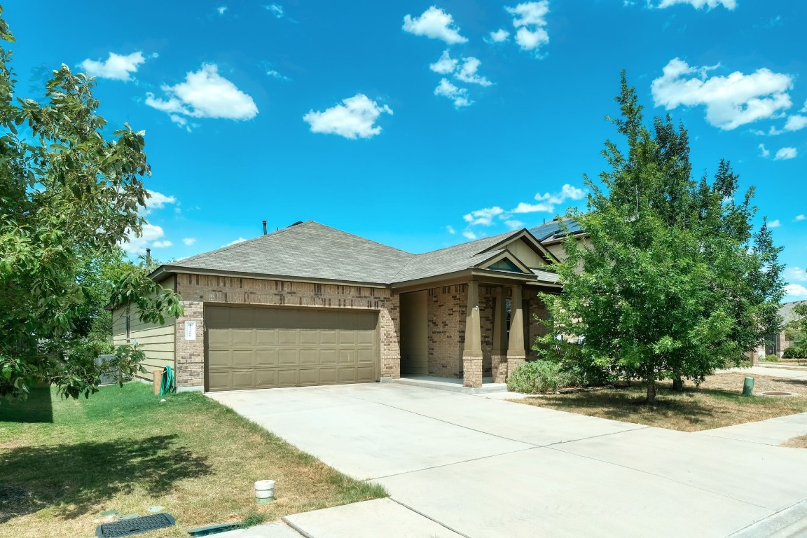 a front view of a house with a yard and a garage