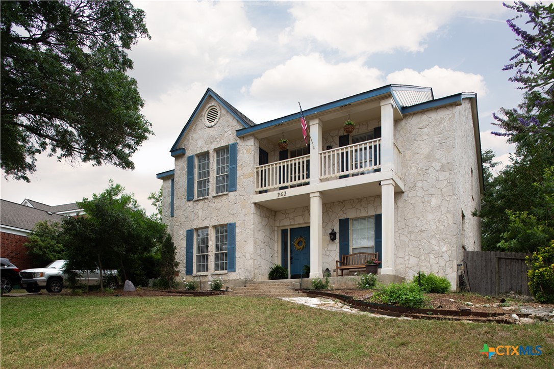 a front view of a house with a yard and trees