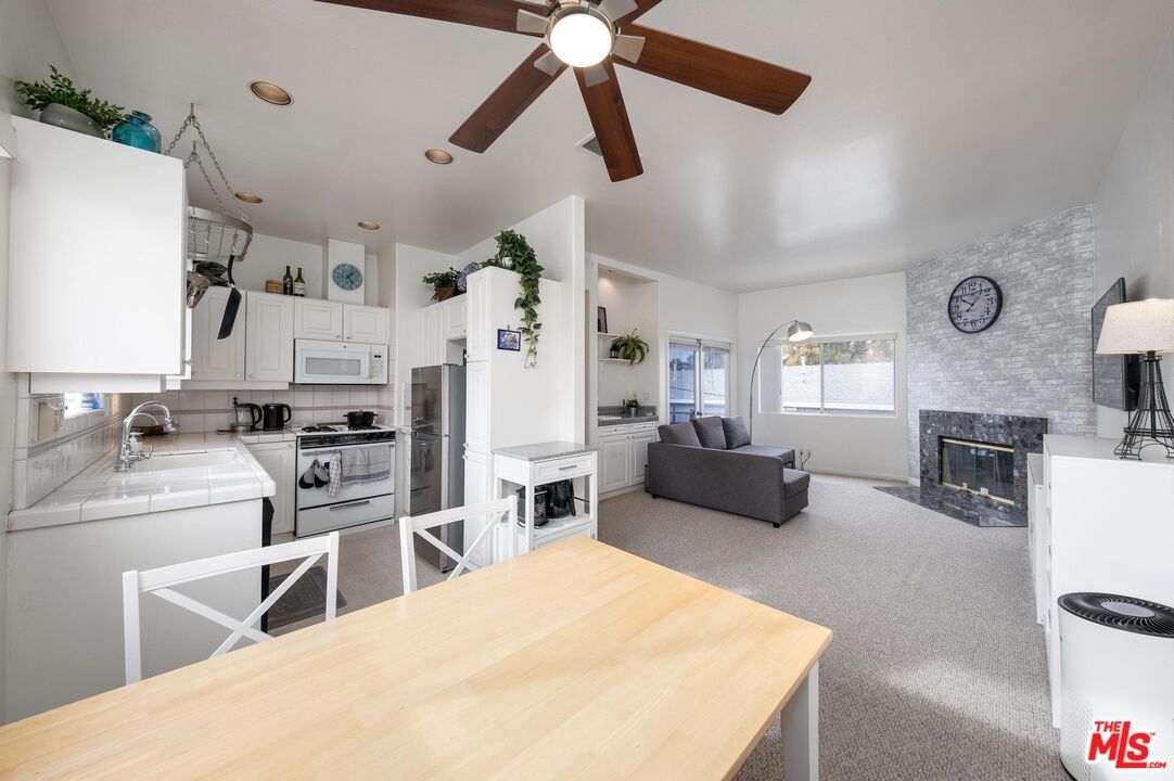 a living room with stainless steel appliances kitchen island a table and a couch