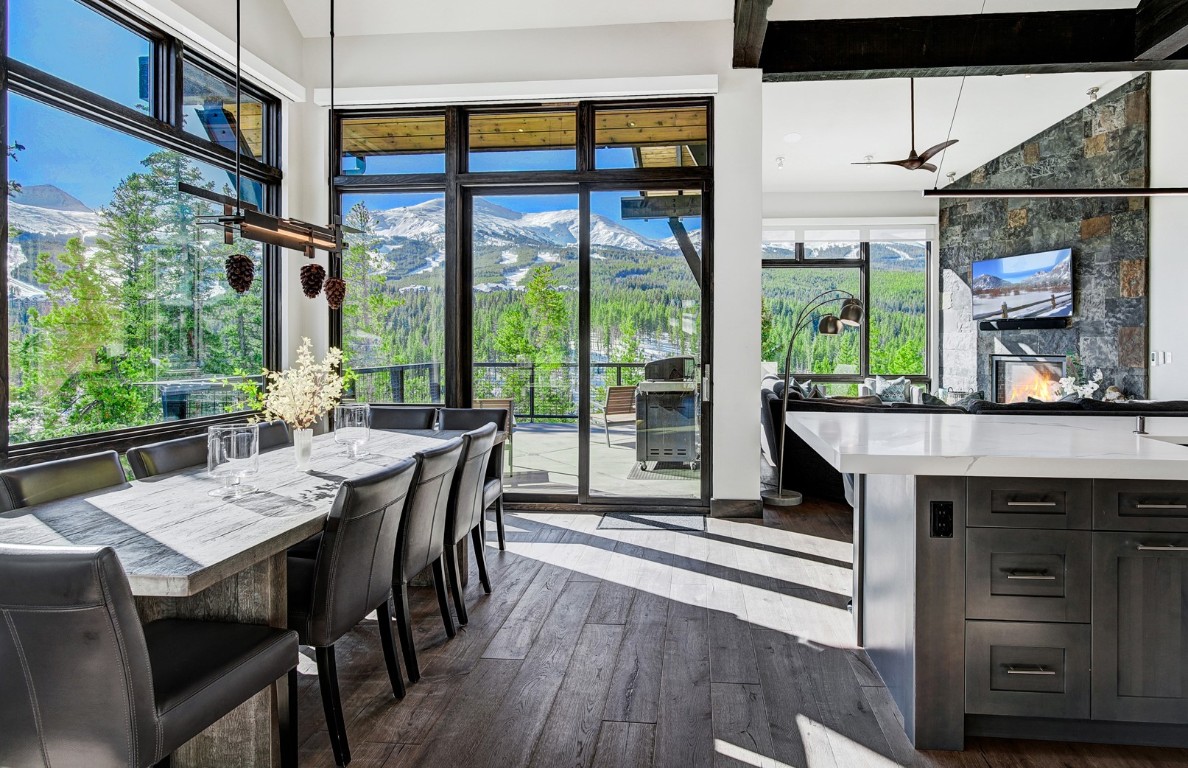 Dining room with beamed ceiling, ceiling fan, and dark wood-type flooring