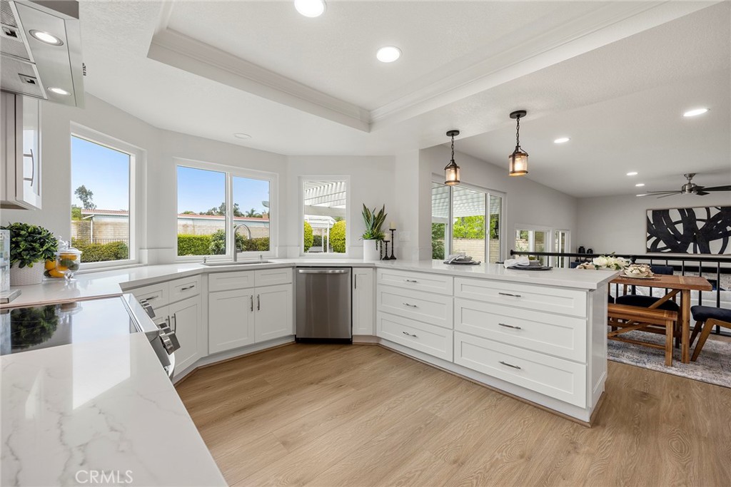 a large white kitchen with kitchen island a sink white cabinets and appliances