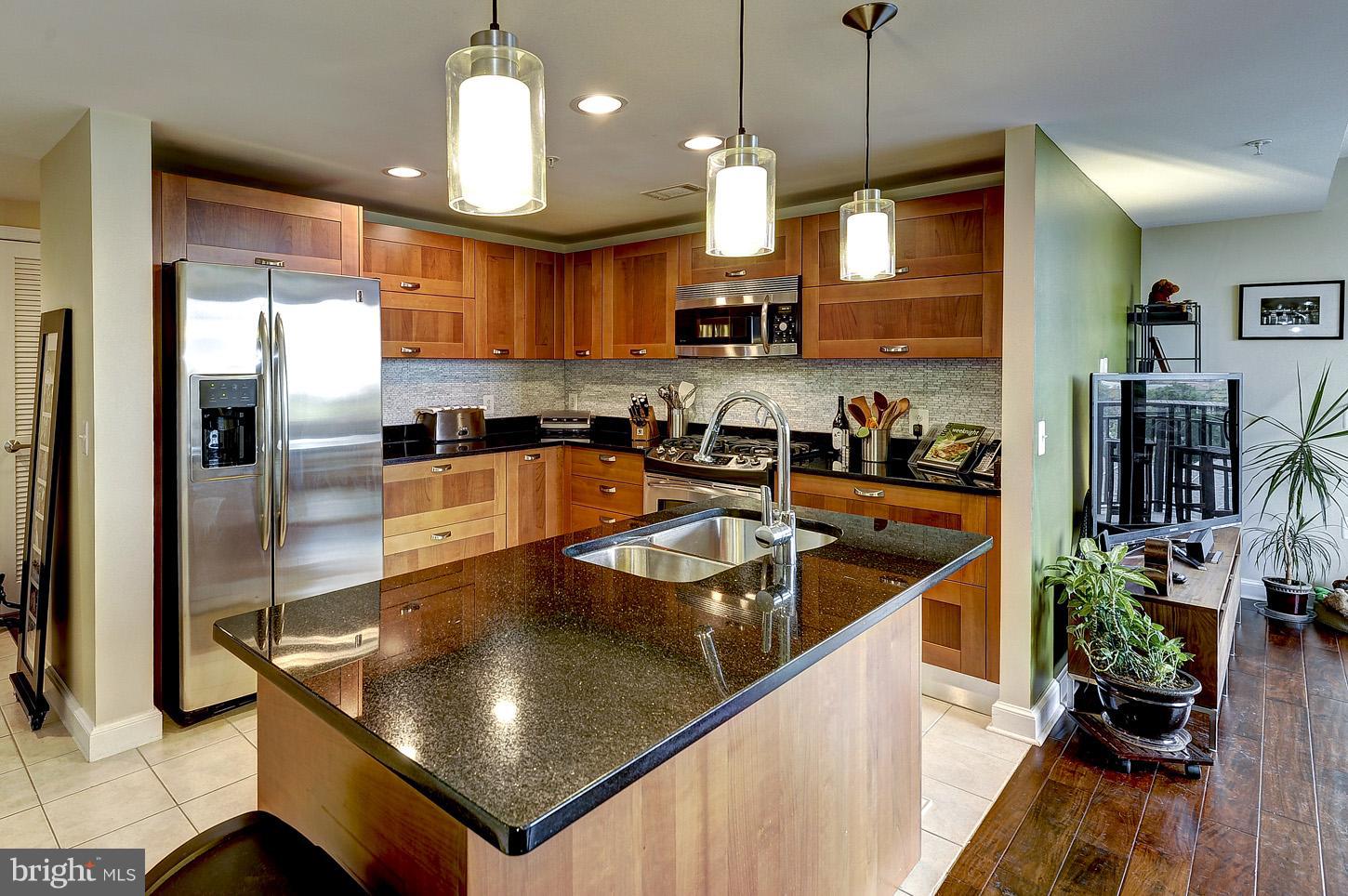 a kitchen with stainless steel appliances granite countertop a sink a stove and a refrigerator