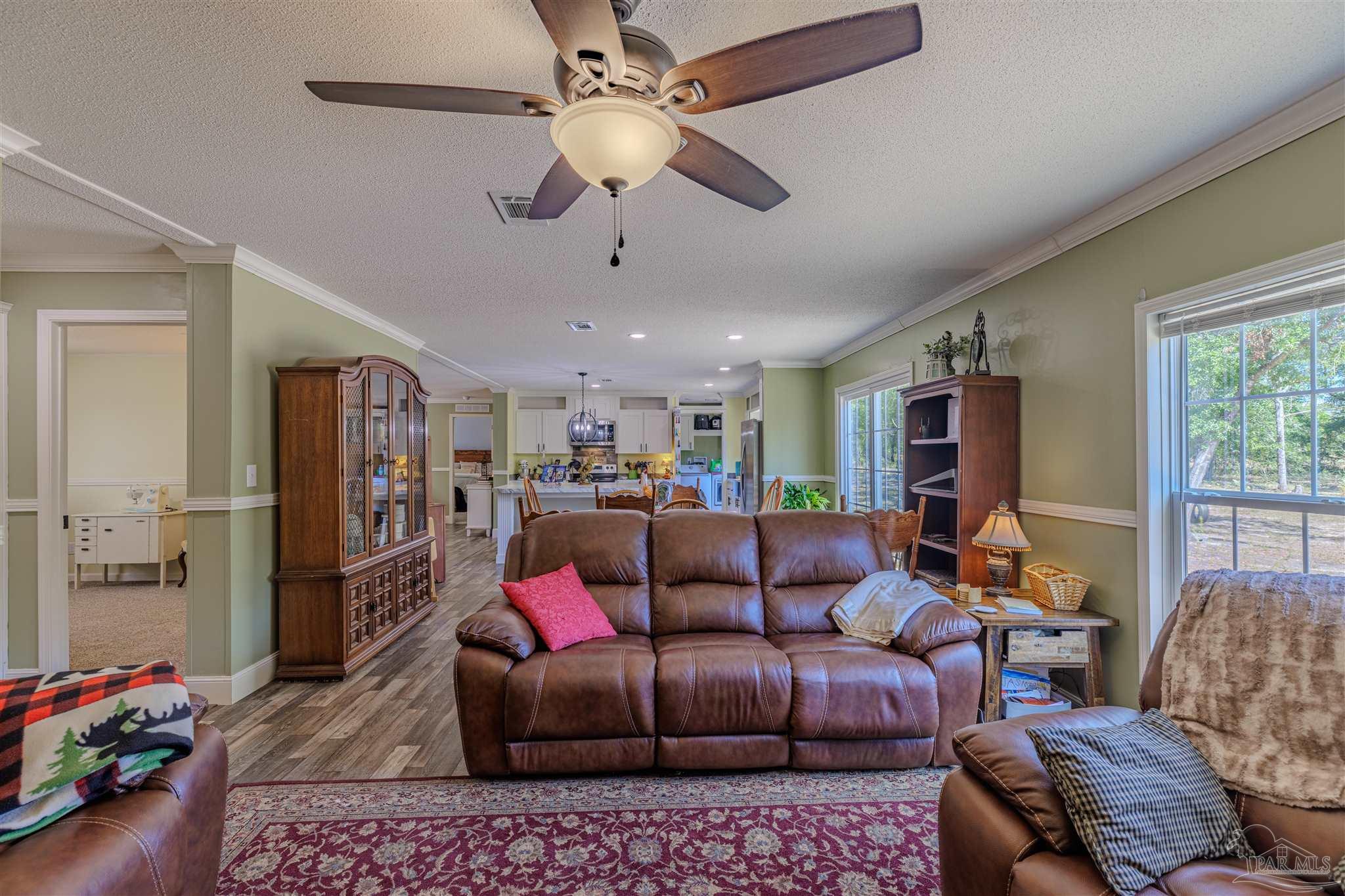 a living room with furniture ceiling fan and a window