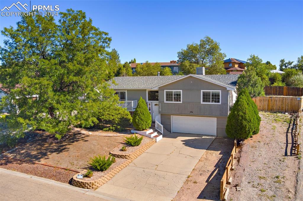 View of front facade featuring a 2 car garage and additional parking with access to back yard.