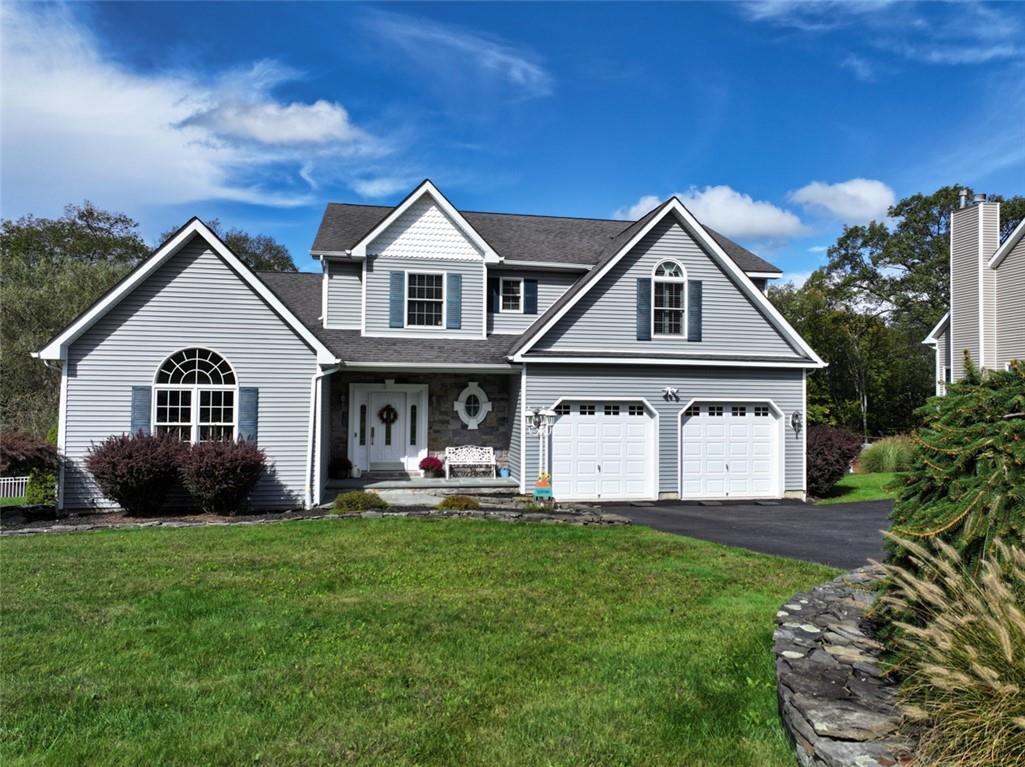 View of front of house with a garage and a front lawn