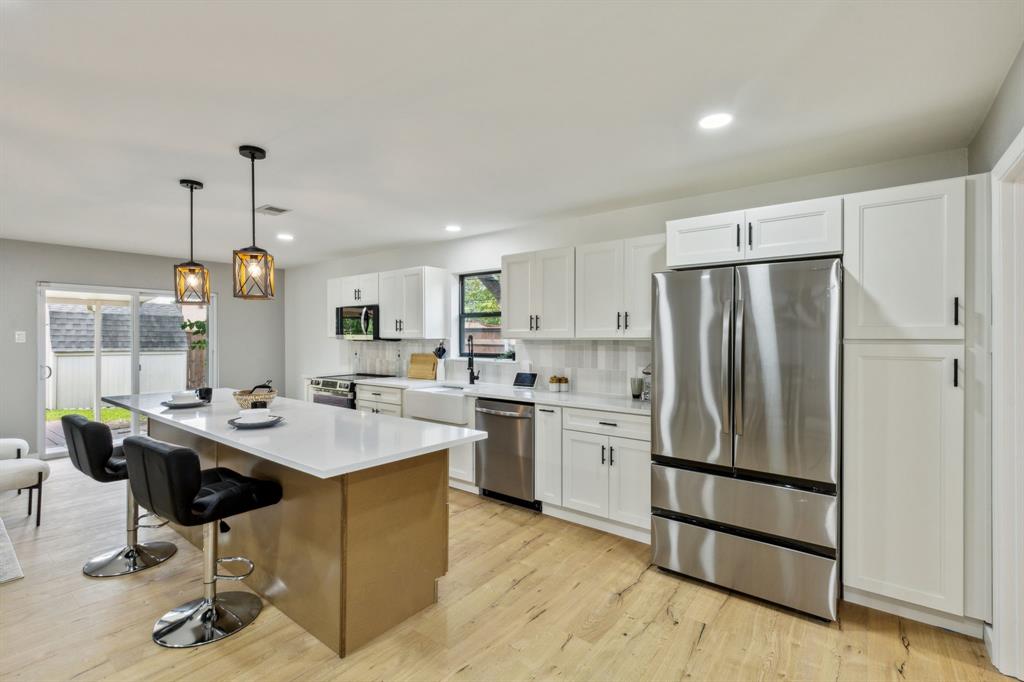 a kitchen with stainless steel appliances granite countertop a sink stove and refrigerator