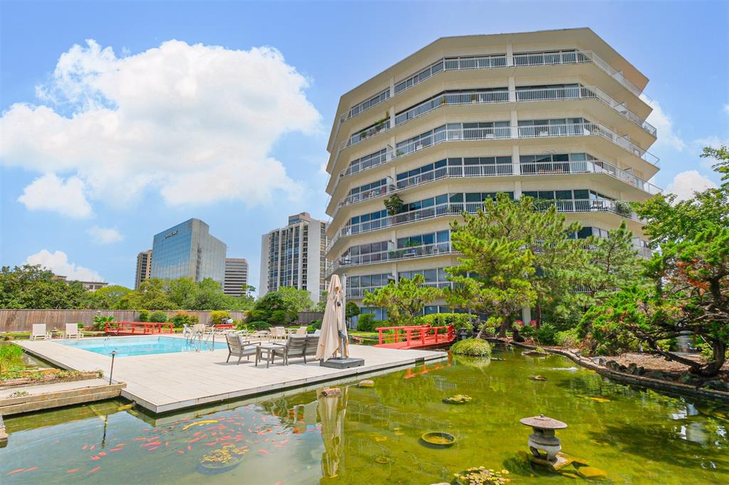 a view of an buildings with a swimming pool and lawn chairs