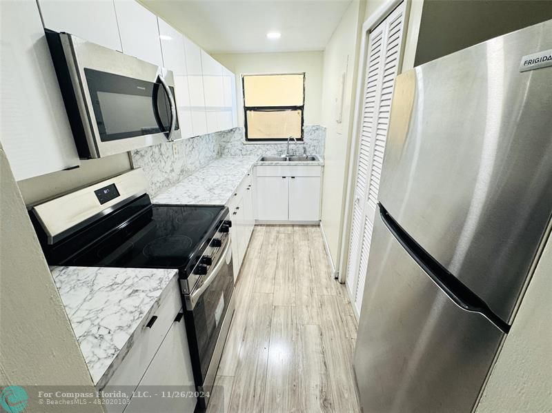 a kitchen with a sink stove and refrigerator