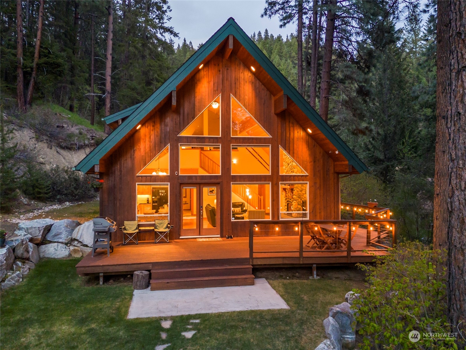 a backyard of a house with wooden floor and outdoor seating