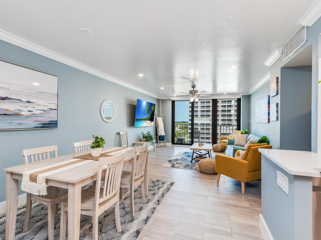 a living room with furniture kitchen view and a large window