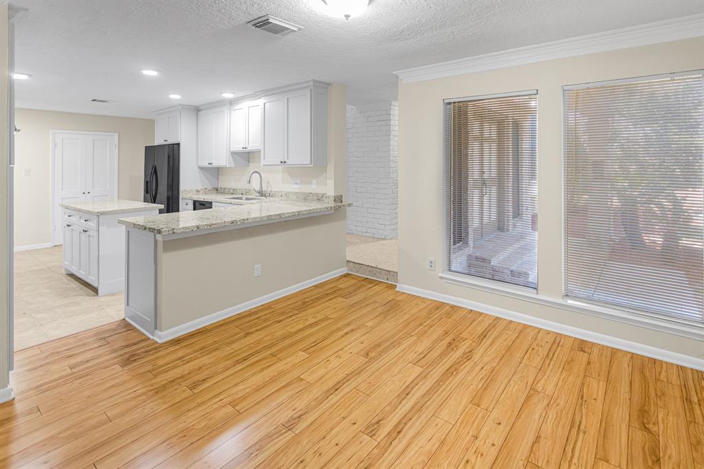 a kitchen with stainless steel appliances granite countertop a white cabinets and wooden floors