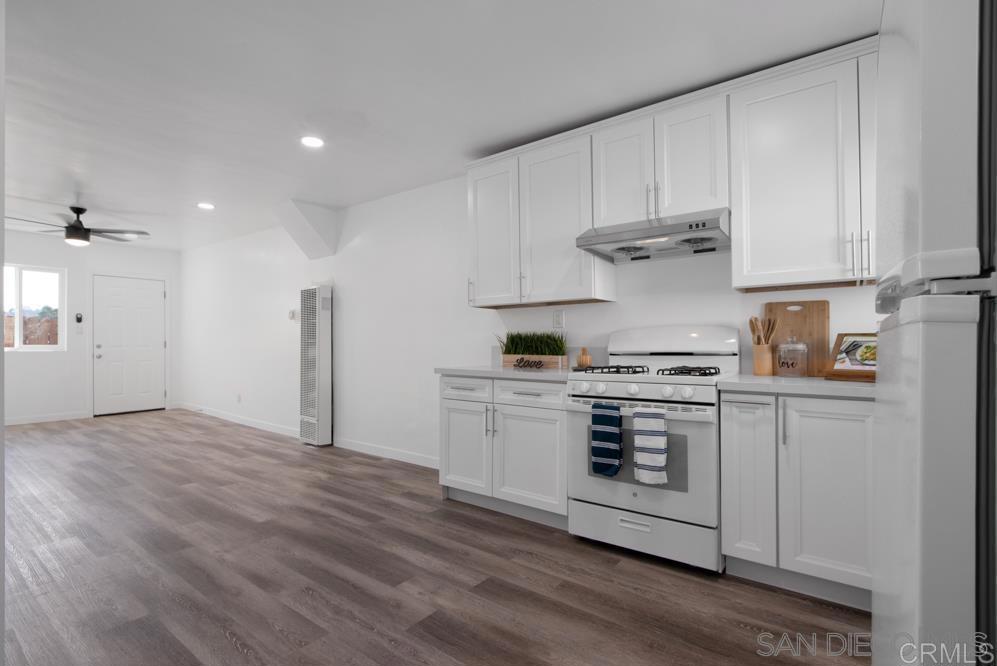 a kitchen with stainless steel appliances granite countertop a stove and white cabinets