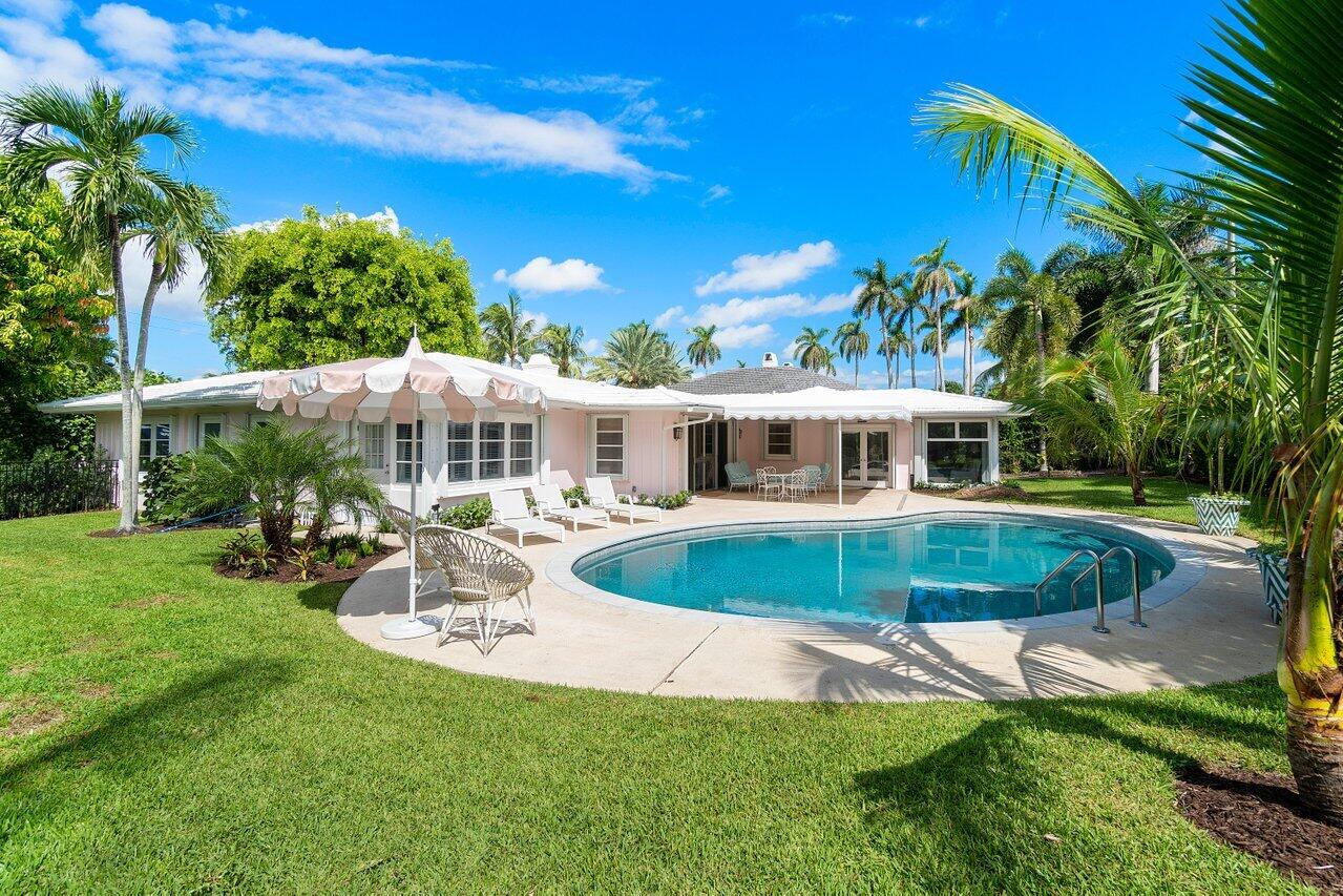 a front view of a house with swimming pool having outdoor seating