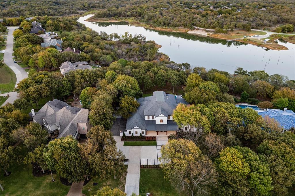 A sweeping aerial view showcasing the property's expansive lot surrounded by lush greenery and overlooking the serene Lake Grapevine.