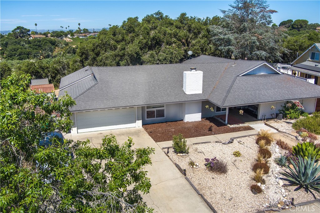 an aerial view of a house with a yard and mountain view in back