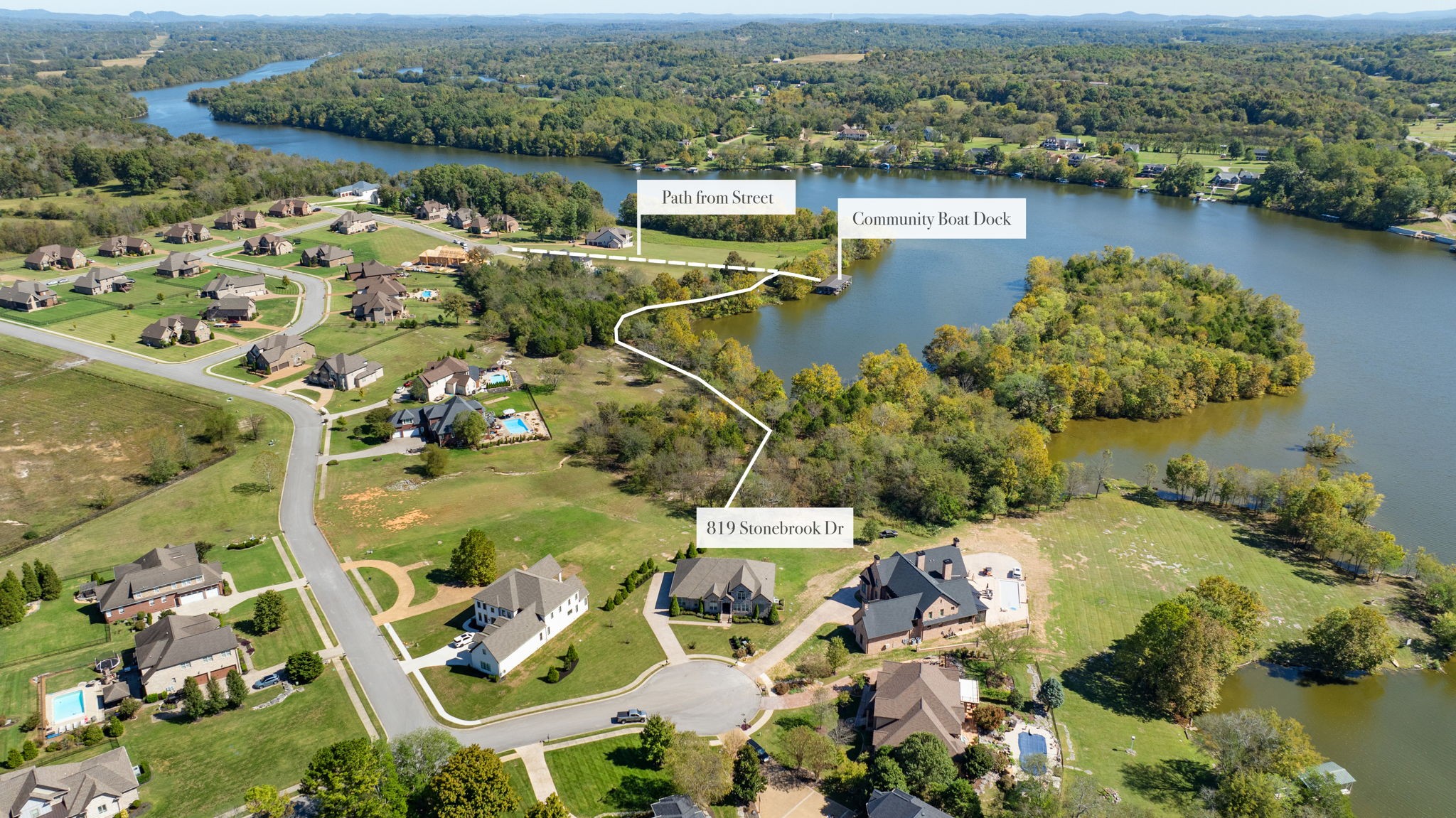 an aerial view of residential houses with outdoor space and lake view