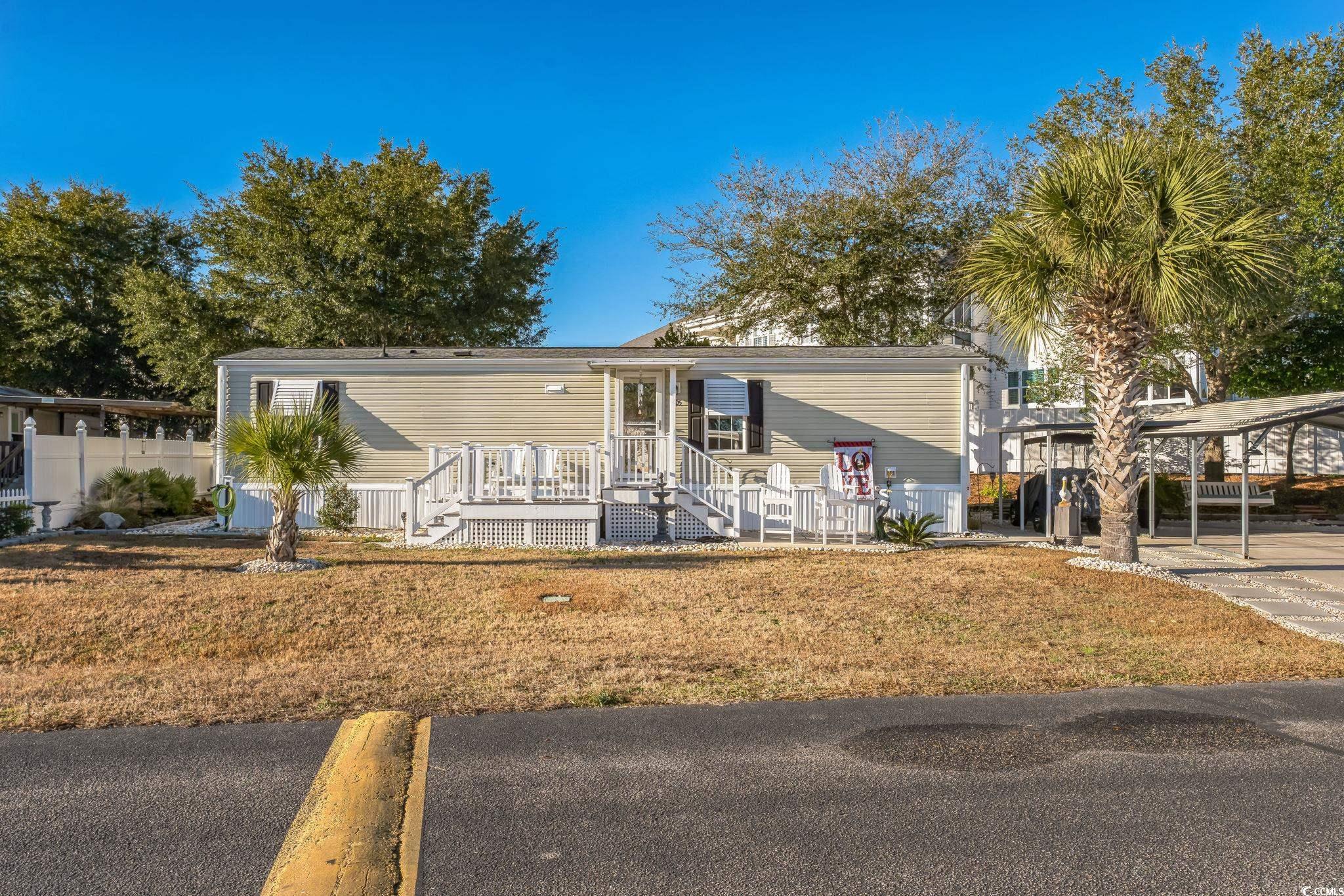 View of front of house with a front yard and a car