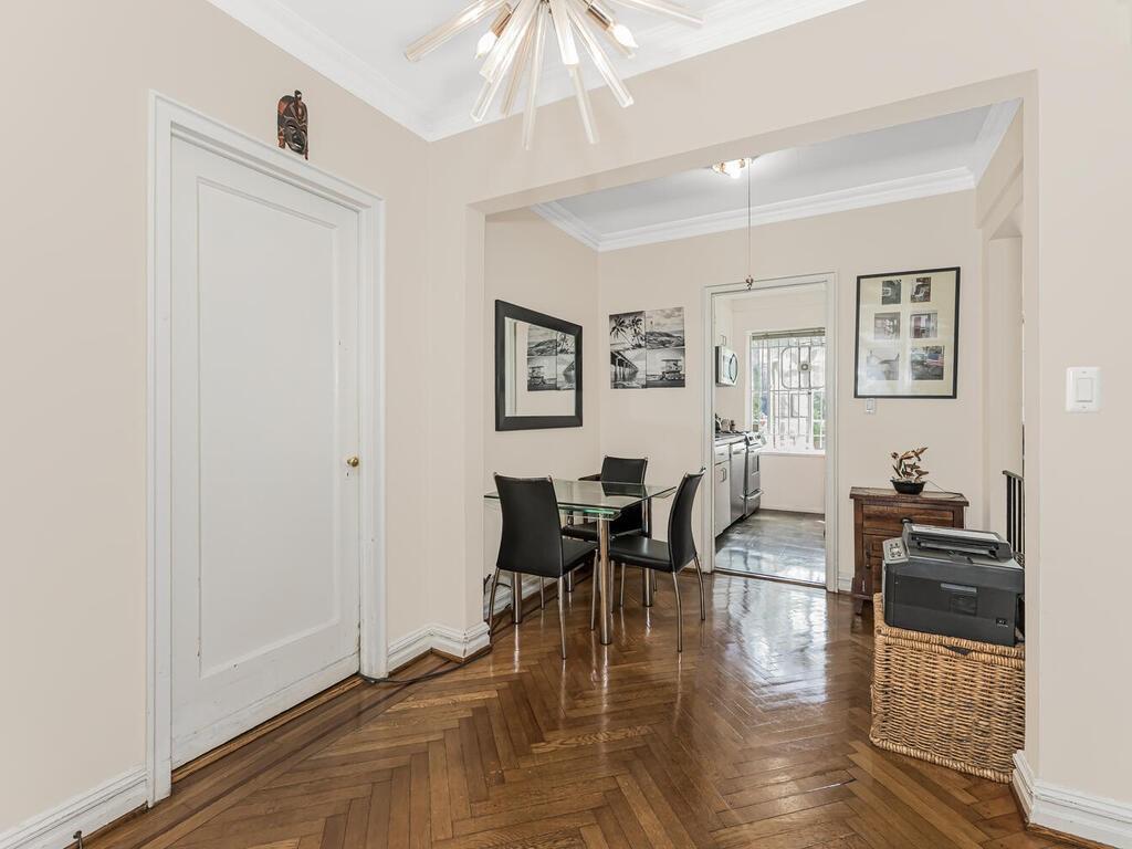 a dining room with wooden floor and white walls