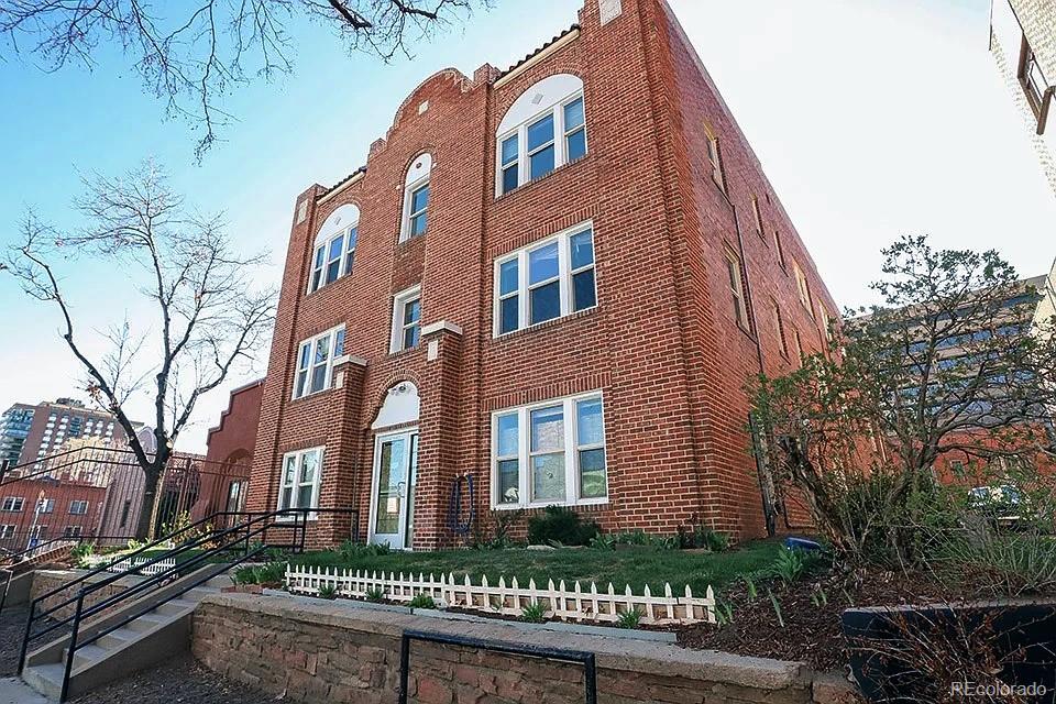 a front view of a residential apartment building with a yard