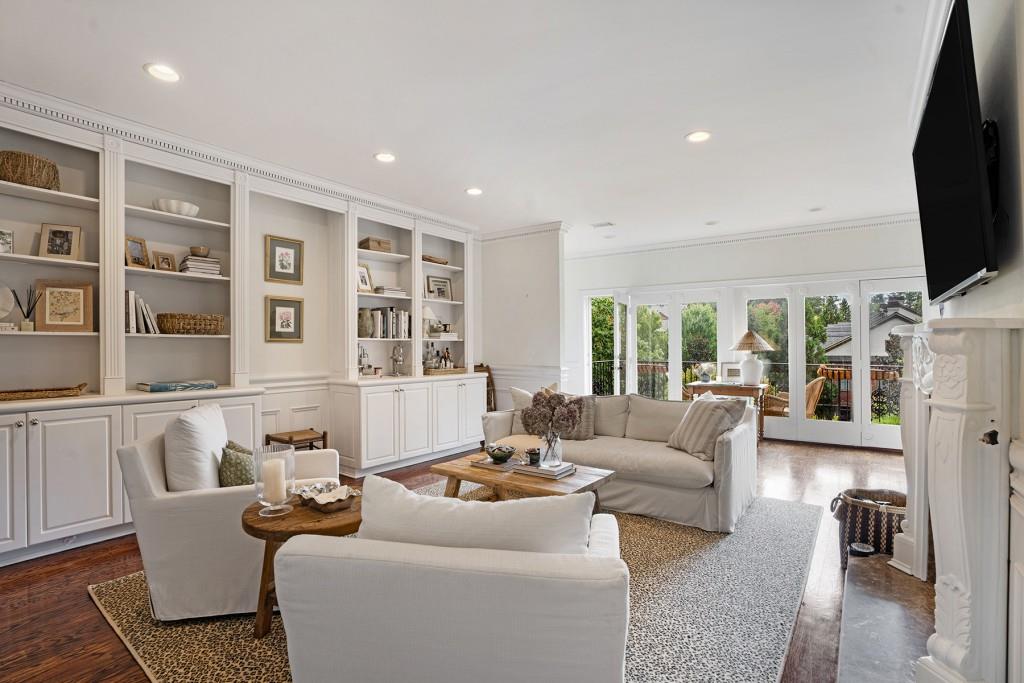 a living room with furniture floor to ceiling window and a flat screen tv