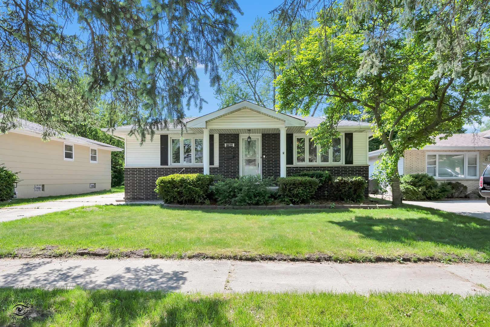 a front view of a house with a garden and yard