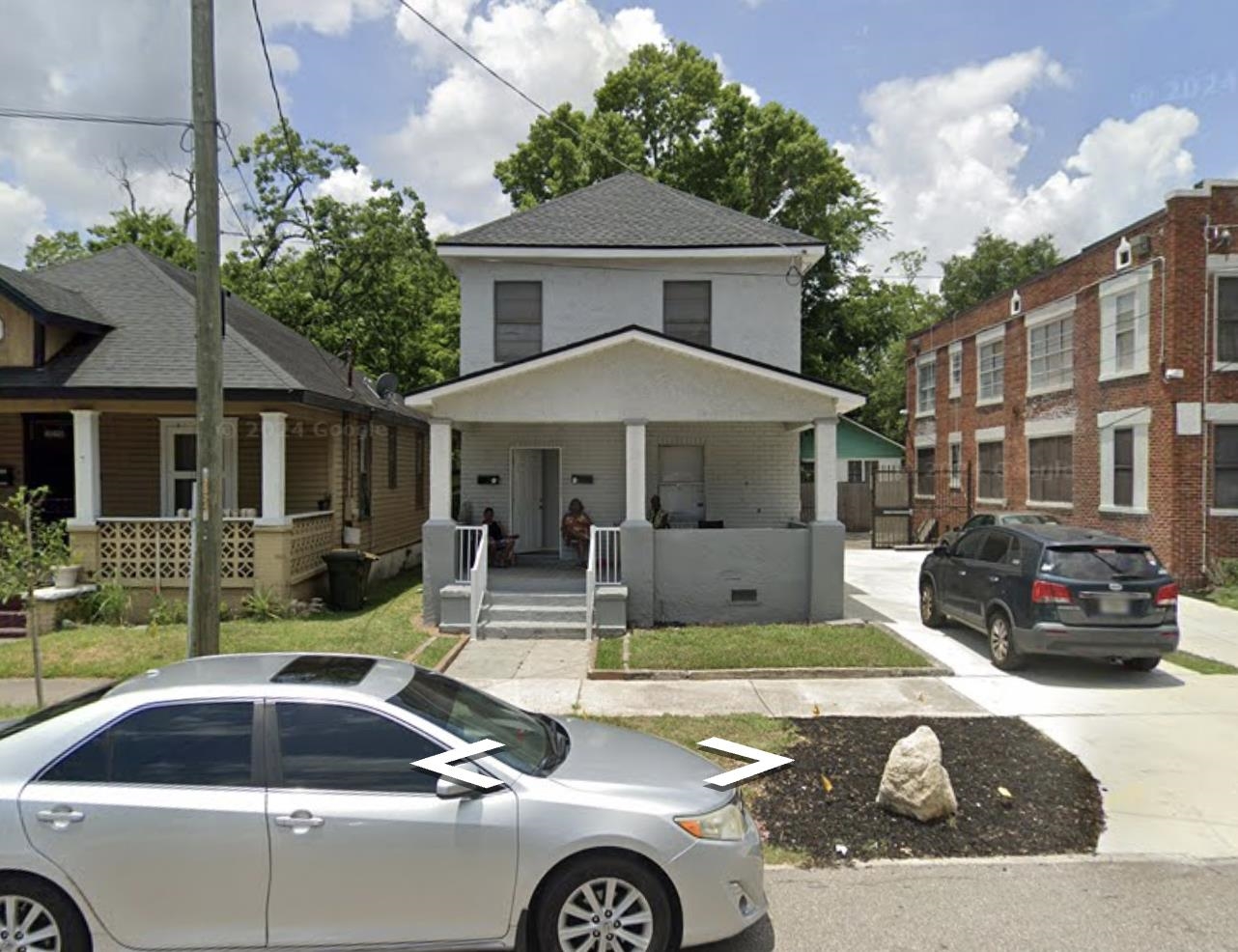 a front view of a house with swimming pool table and chairs