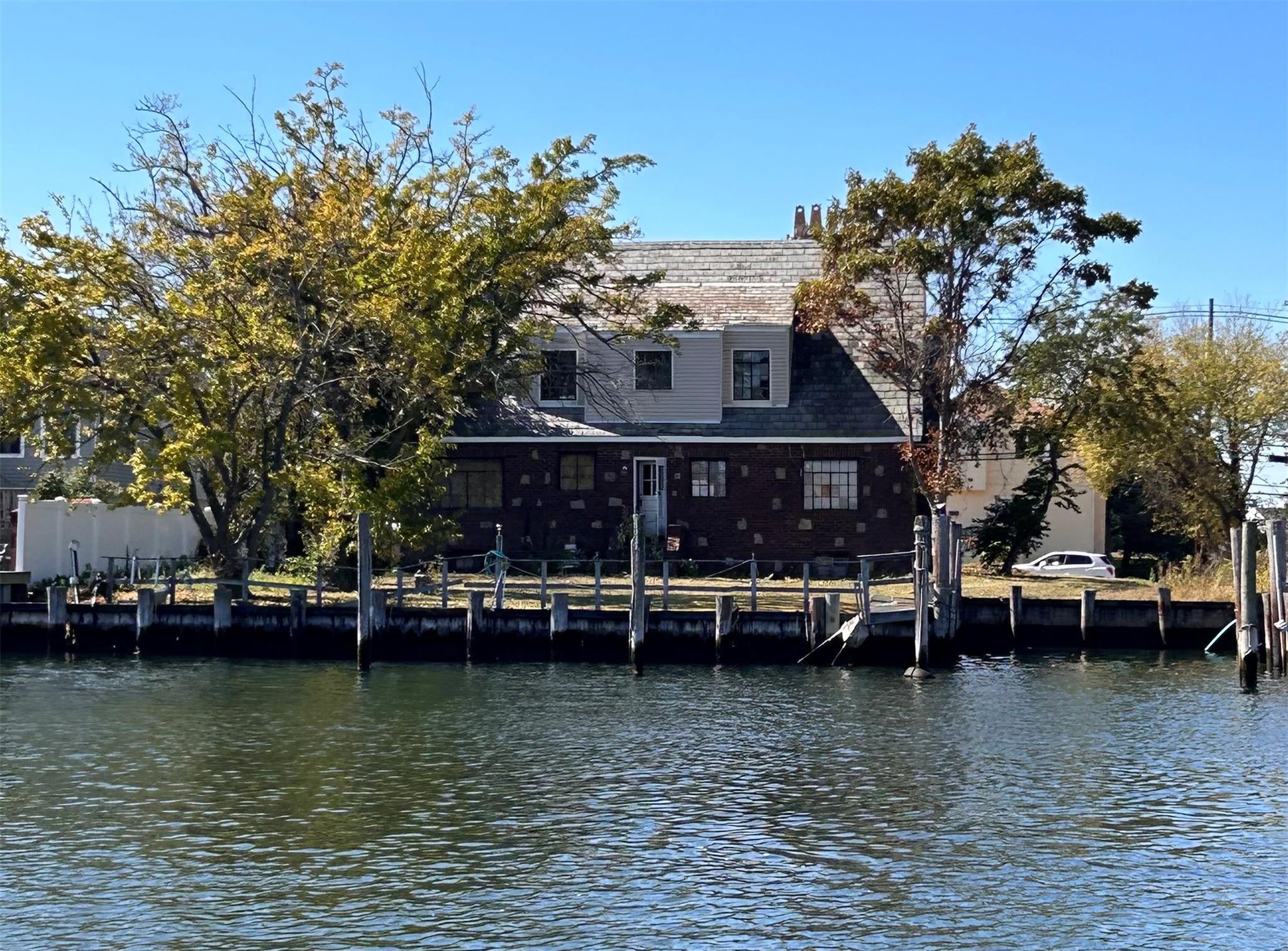 a view of house with swimming pool and trees in the background