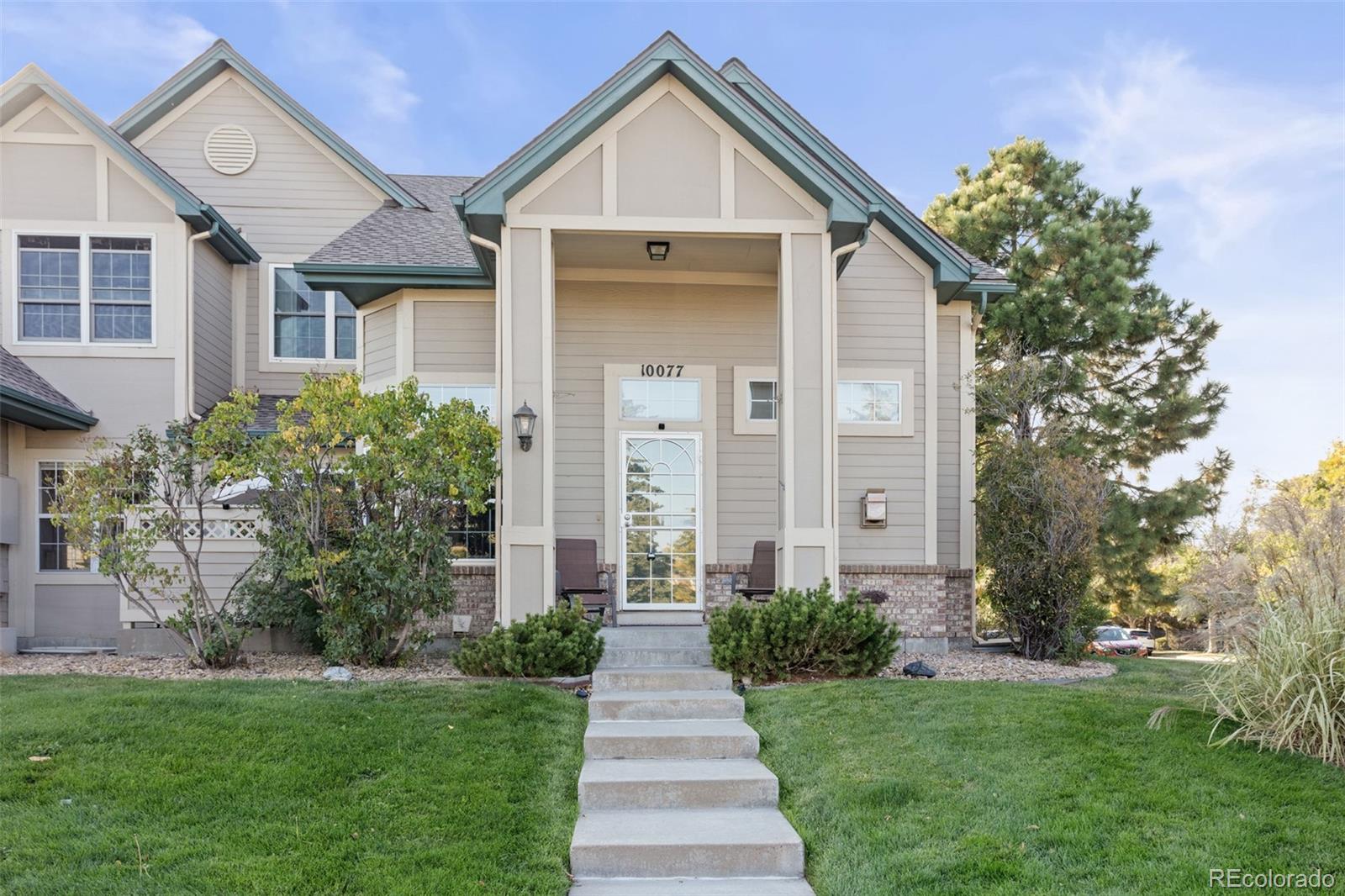 a front view of a house with a yard and trees