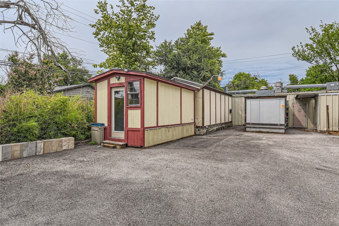 a view of a small house with wooden fence