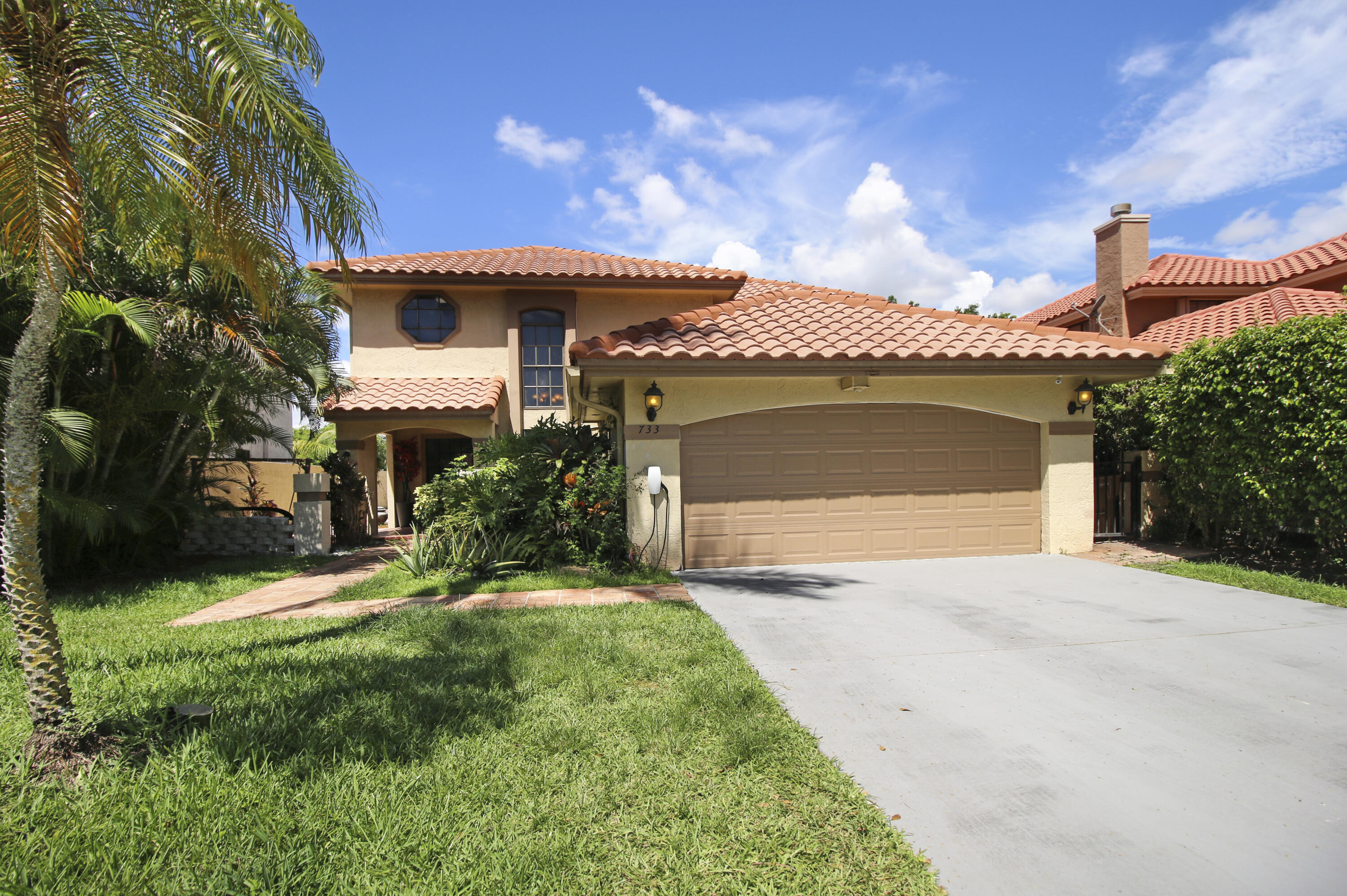 a front view of a house with a garden and yard