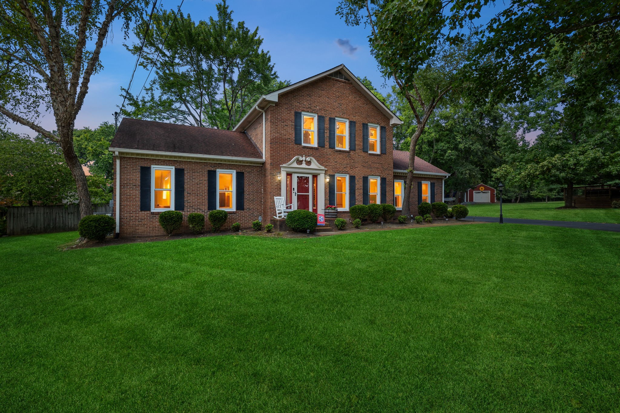 a front view of a house with a yard and trees