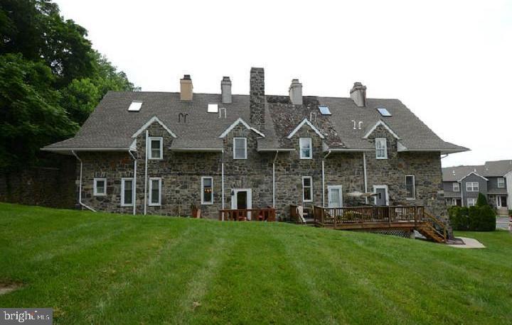 a front view of a house with a garden and chairs