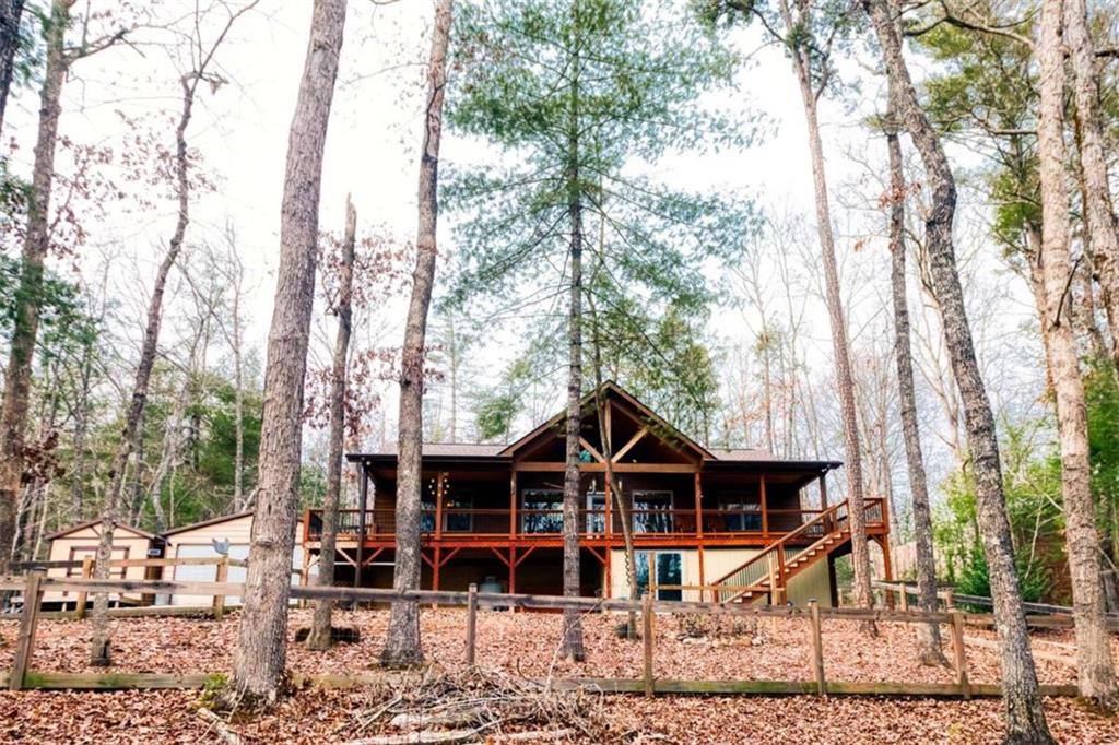 a view of a wooden house with trees in the background